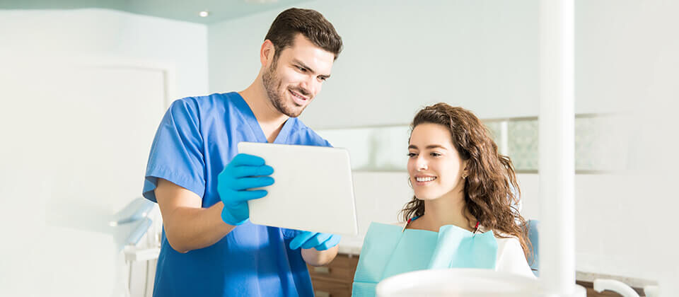 A professional dentist is checking the patient