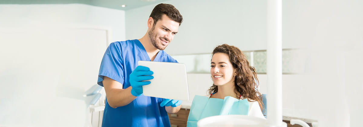 A professional dentist is checking the patient