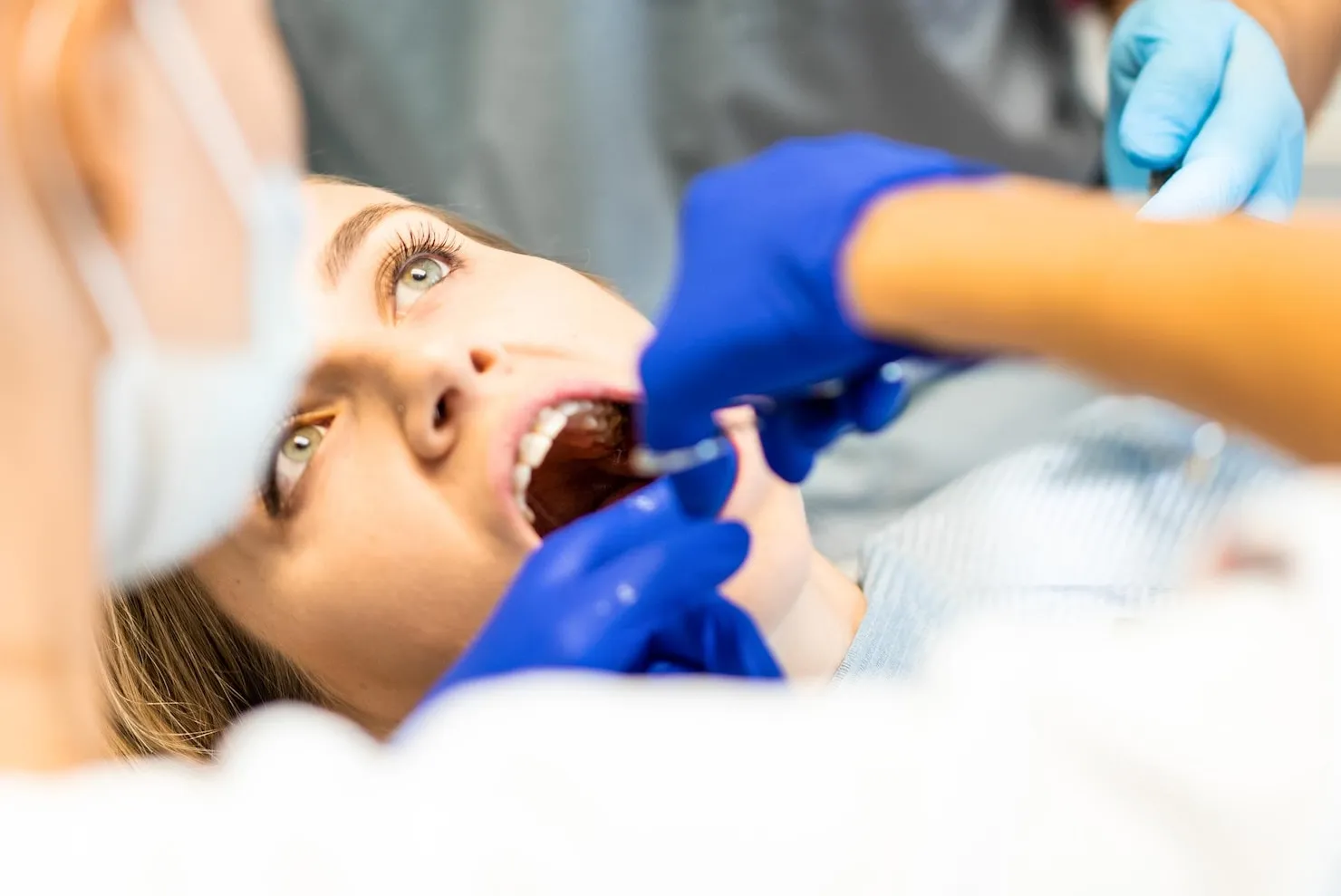 Dentist performing wisdom teeth removal procedure at modern dental office