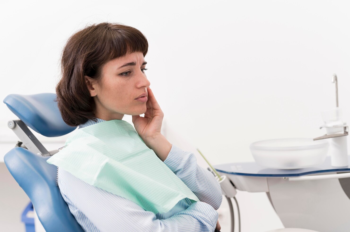 Woman having tooth pain visiting dentist for wisdom teeth removal treatment