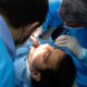 Dental professional carrying out wisdom teeth extraction procedure.