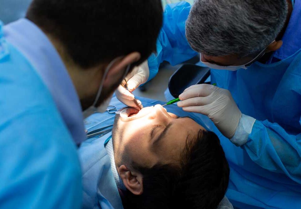 Dental professional carrying out wisdom teeth extraction procedure.