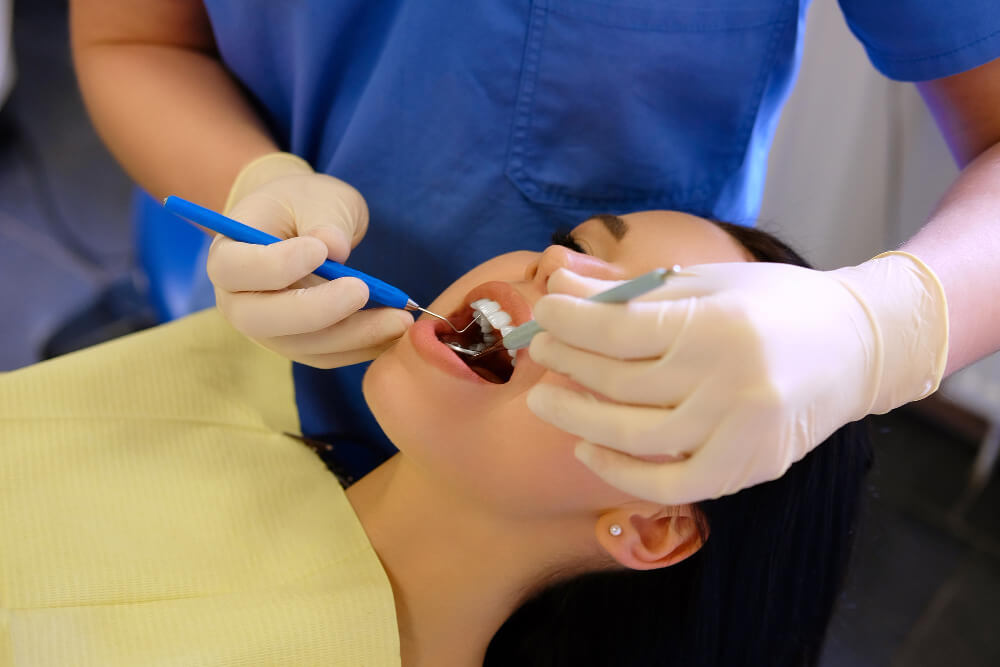 Female patient receiving tooth extraction procedure at dental clinic