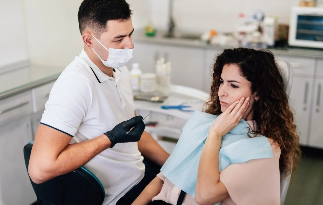Dentist examining woman with wisdom tooth pain before wisdom teeth removal