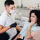 Dentist examining woman with wisdom tooth pain before wisdom teeth removal
