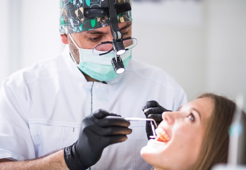 Patient receiving professional dental treatment from a dentist inside a modern dental clinic
